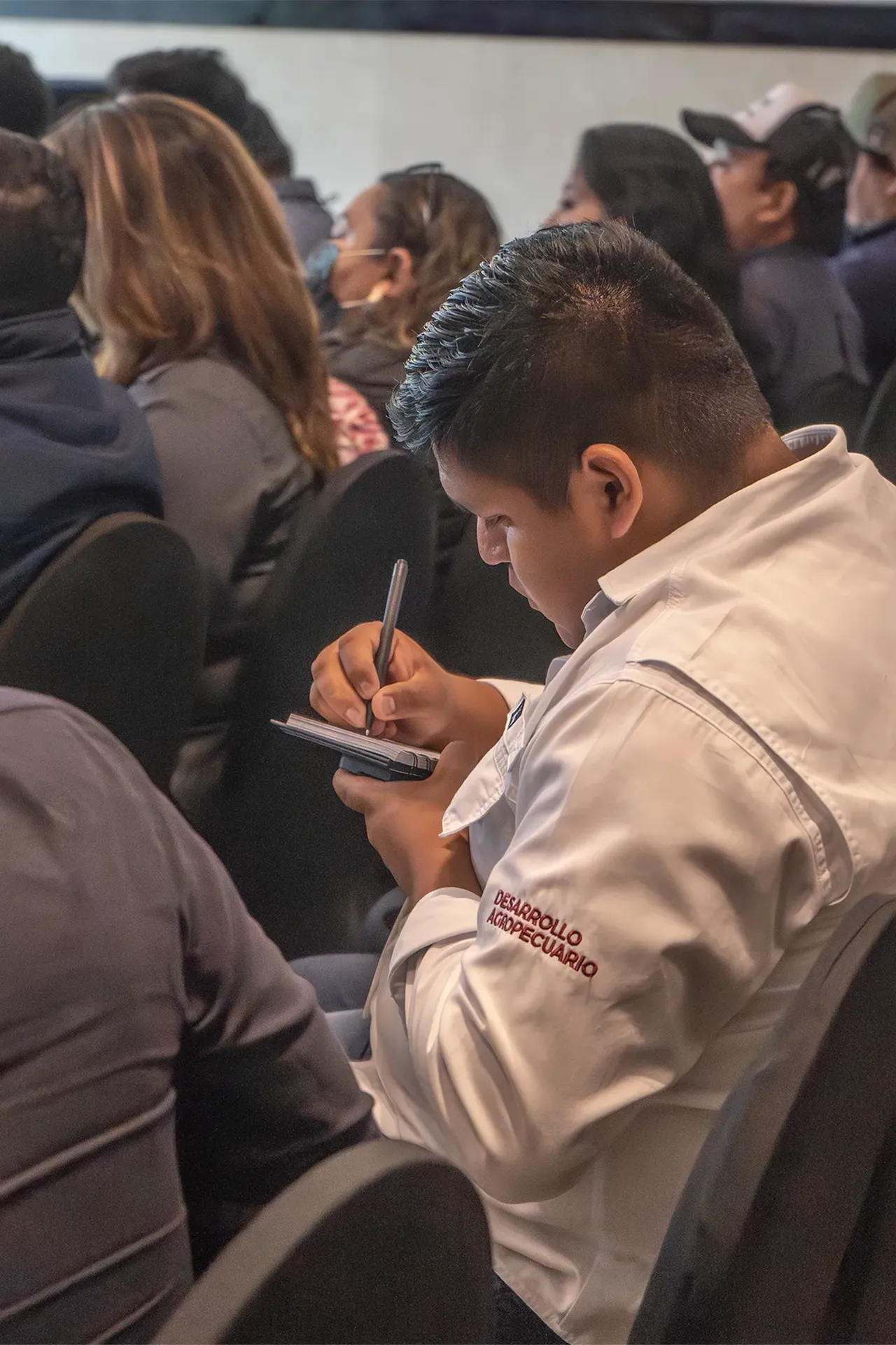 Asistente tomando notas en conferencia